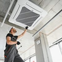 Happy Male Technician Repairing Air Conditioner.