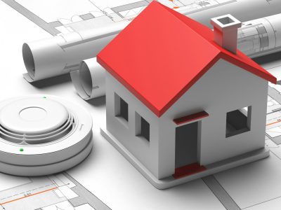 Smoke detector and small house on blueprint drawing background. Fire safety system. 3d illustration