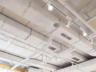 Ventilation ducts system painted in white composition of fire protection under the ceiling